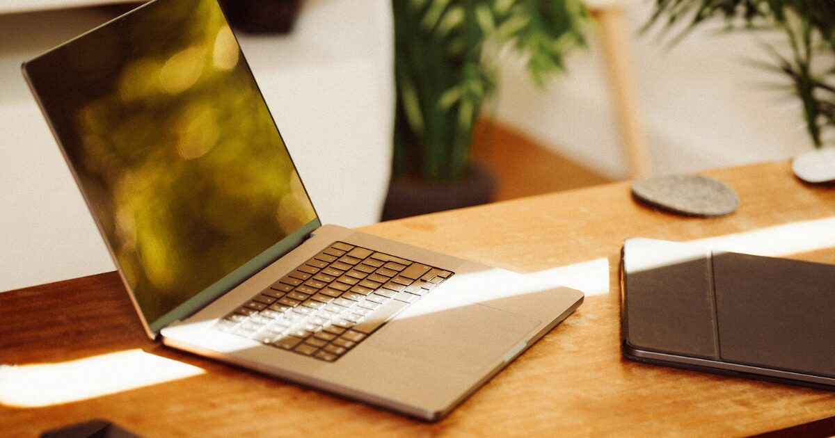 ノートパソコンとタブレットが置かれた木製デスク