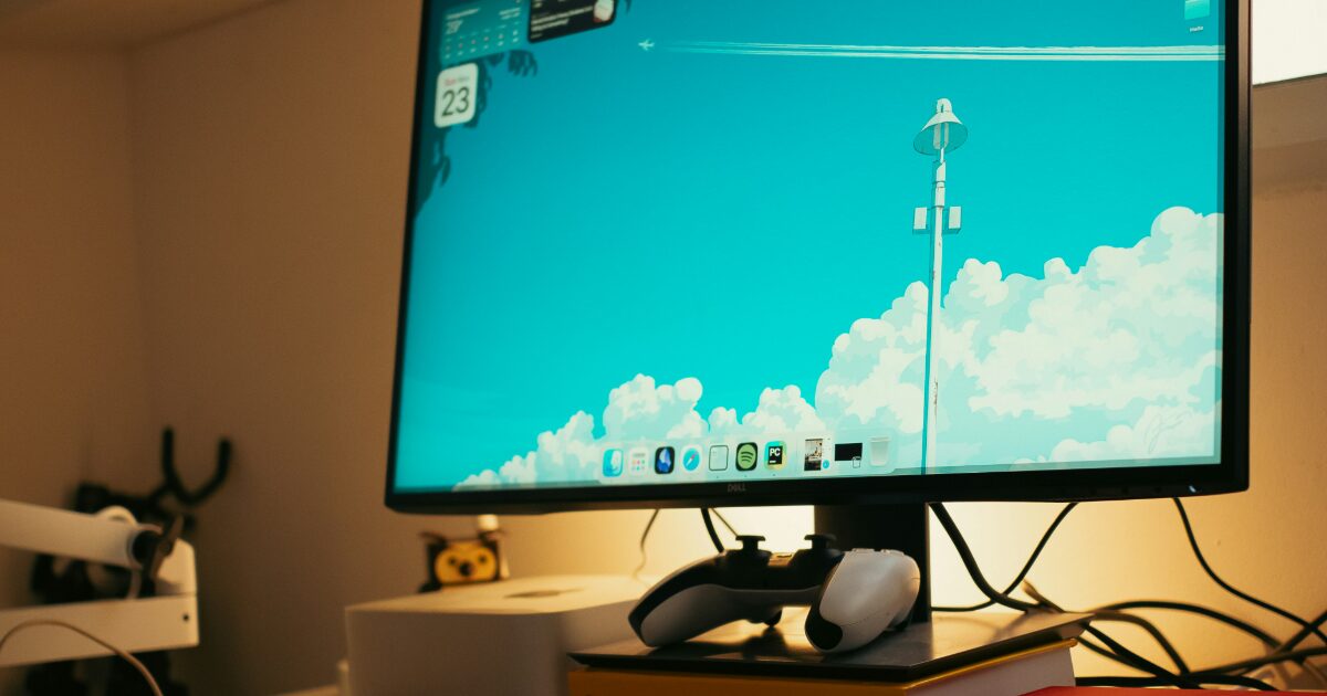アニメ壁紙が表示されたデスクトップモニターとゲームコントローラー