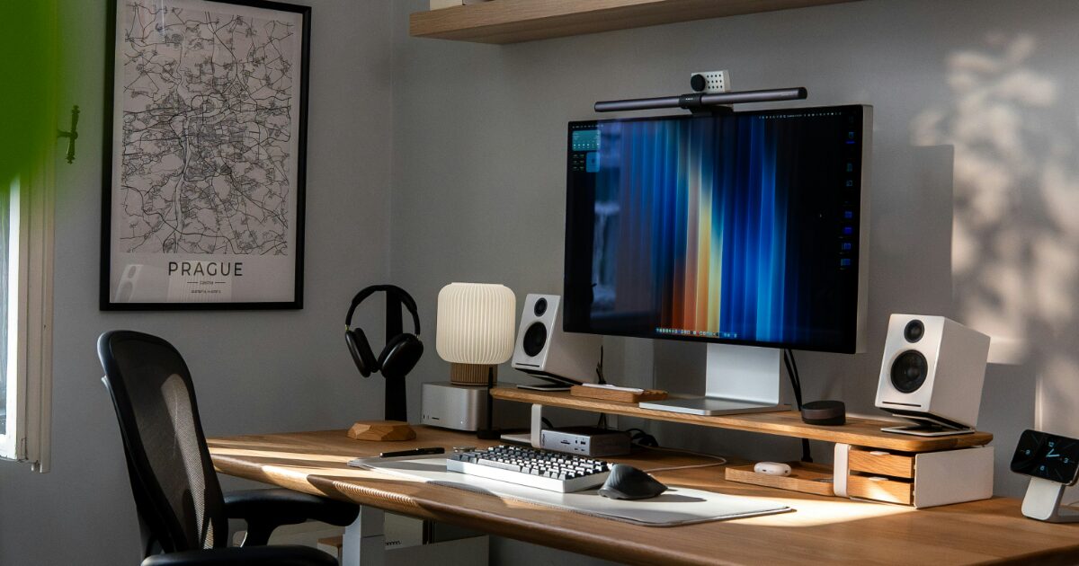 整然としたデスクに大型モニターとスピーカーが配置されたスタイリッシュなホームオフィス